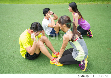 Two groups of young Asian couple helping each other to warm up before an execise in the outdoor park Two groups of young Asian couple helping each other to warm up before an execise in the outdoor park 12075078