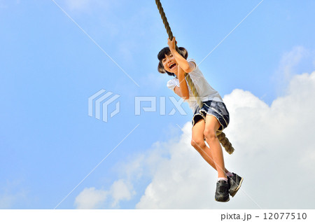 公園の遊具で楽しく遊ぶ女の子 12077510