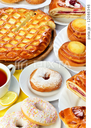 still life of setout table with baking pies, donuts and tee cup 12086346