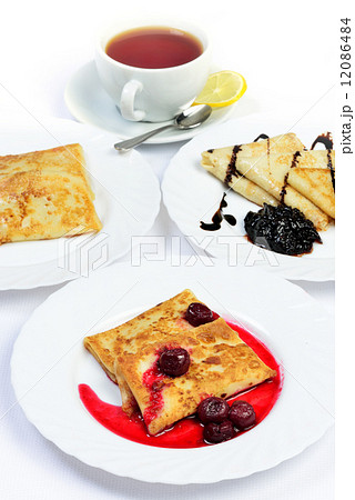Food of Crepes, cheesecakes with berry sause and cup of tee. Food of Crepes, cheesecakes with berry sause and cup of tee. 12086484