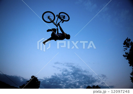 Silhouette of a man doing a jump with a bmx bike Silhouette of a man doing a jump with a bmx bike 12097248