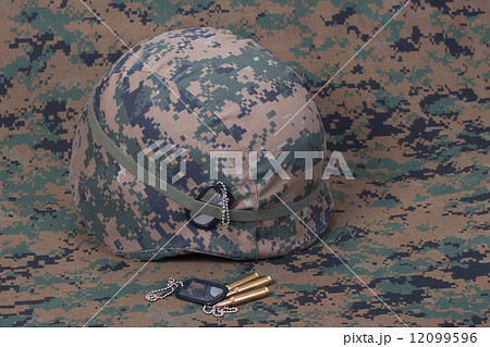 kevlar helmet with dog tags and cartridges on camouflage cover kevlar helmet with dog tags and cartridges on camouflage cover 12099596