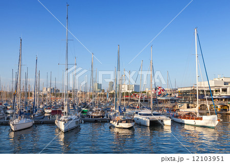 Sailing yachts and pleasure boats are moored in Barcelona port 12103951