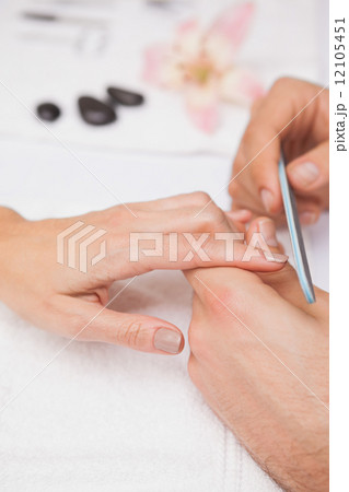 Manicurist filing a customers nails 12105451