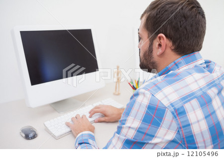 Casual businessman working at his desk 12105496