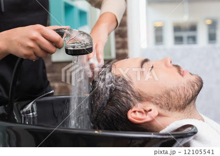 Hair stylist washing mans hair 12105541