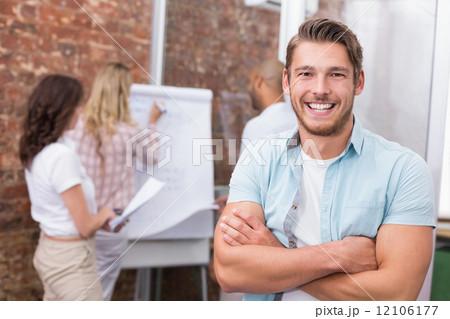 Casual businessman smiling at camera with arms crossed 12106177