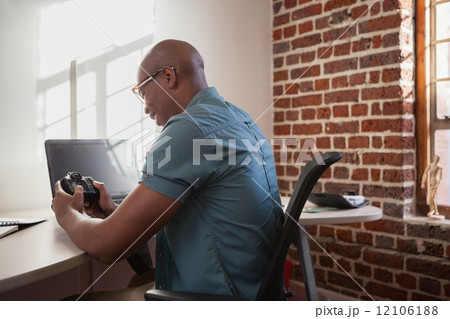 Casual photographer looking at his camera 12106188