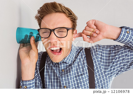 Geeky businessman eavesdropping with cup 12106978