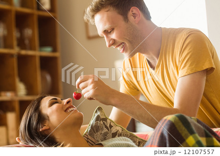Young couple cuddling on the couch under blanket 12107557