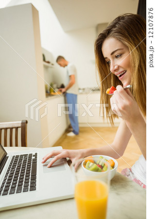 Woman eating fruit salad at breakfast 12107876