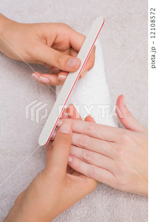 Nail technician giving customer a manicure Nail technician giving customer a manicure 12108572