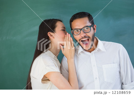Casual woman whispering secret into friends ear Casual woman whispering secret into friends ear 12108659