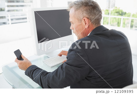 Businessman using his smart phone Businessman using his smart phone 12109395