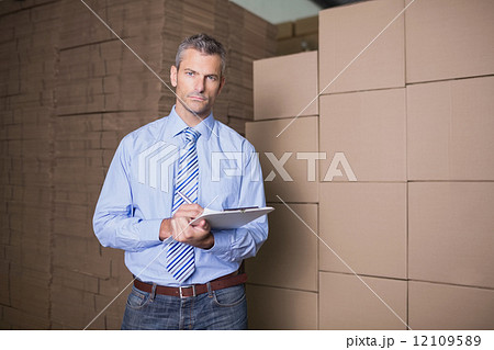 Portrait of manager with clipboard in warehouse 12109589