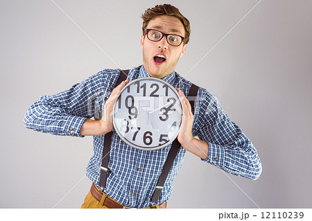 Geeky businessman holding a clock Geeky businessman holding a clock 12110239