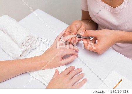Nail technician giving customer a manicure Nail technician giving customer a manicure 12110438
