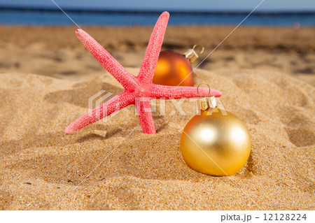 christmas balls with starfush on beach 12128224