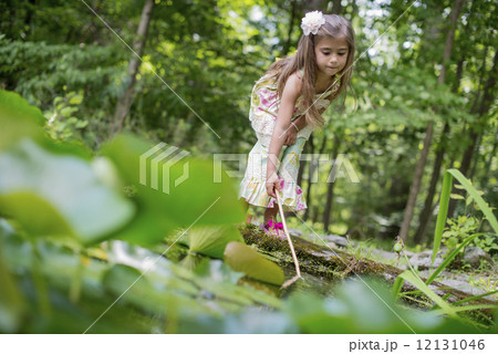 A girl playing at a pond in a forest. A girl playing at a pond in a forest. 12131046