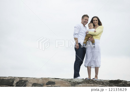 Young Family together on beach. 12135629