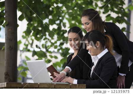 3 businesswoman working together onlaptop. 12135975