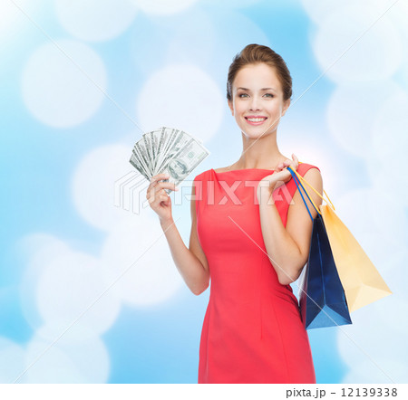 smiling woman in red dress with shopping bags 12139338