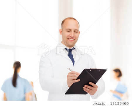 smiling male doctor with clipboard smiling male doctor with clipboard 12139460