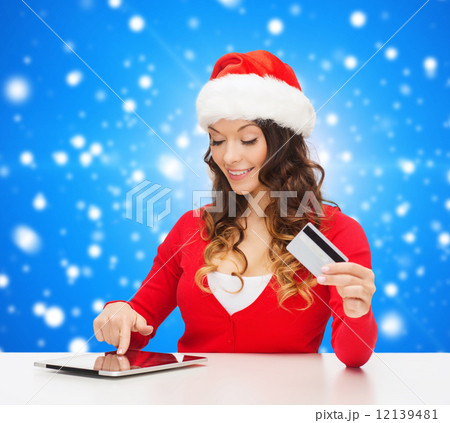 smiling woman with credit card and tablet pc 12139481