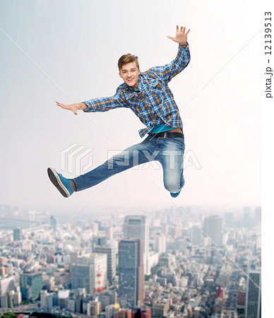 smiling young man jumping in air 12139513