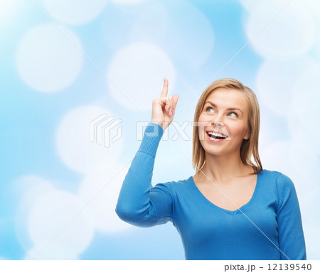 smiling woman pointing her finger up smiling woman pointing her finger up 12139540