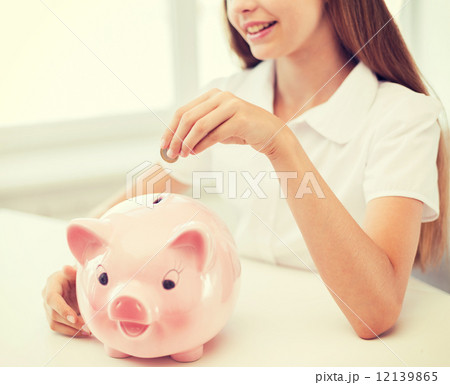 smiling child putting coin into big piggy bank smiling child putting coin into big piggy bank 12139865
