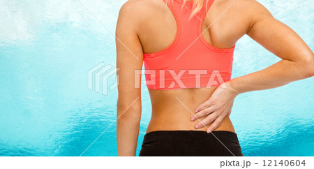 close up of sporty woman touching her back 12140604