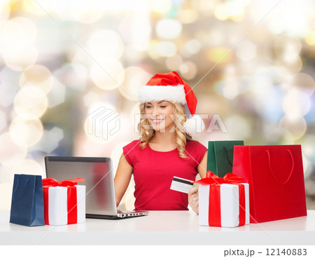 smiling woman with credit card and laptop 12140883