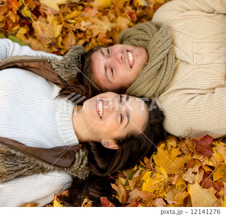 close up of smiling couple lying in autumn park close up of smiling couple lying in autumn park 12141276
