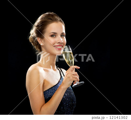 smiling woman holding glass of sparkling wine 12141302