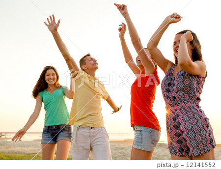 smiling friends dancing on summer beach smiling friends dancing on summer beach 12141552
