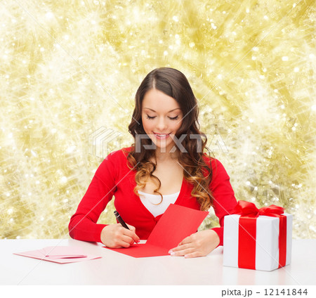 smiling woman with gift box writing letter 12141844
