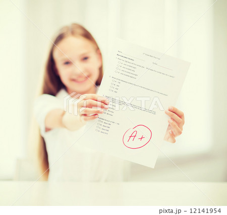 smiling little student girl with test and A grade 12141954