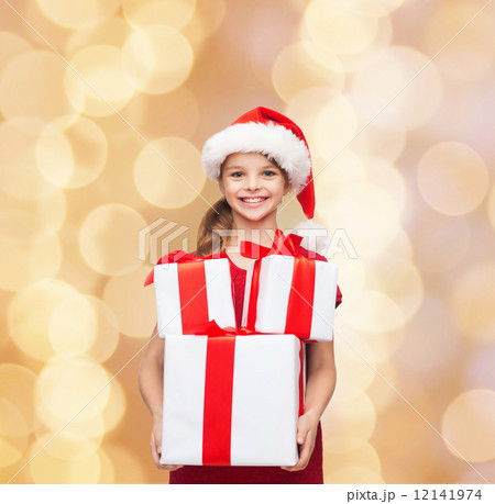 smiling little girl in santa helper hat with gifts 12141974