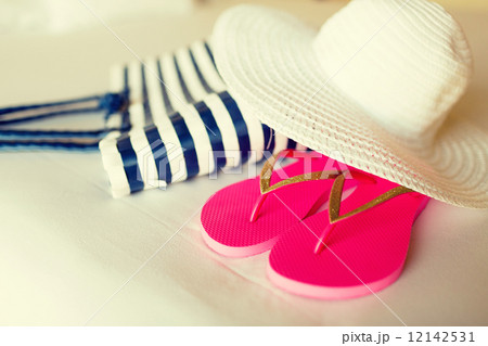 close-up of beach bag, hat and flip-flops on bed close-up of beach bag, hat and flip-flops on bed 12142531