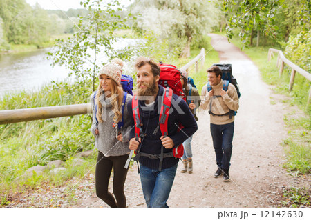 group of smiling friends with backpacks hiking 12142630