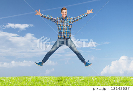 smiling young man jumping in air 12142687
