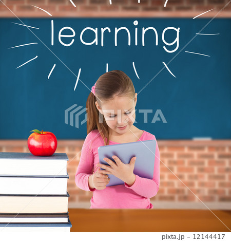 Learning against red apple on pile of books in classroom 12144417