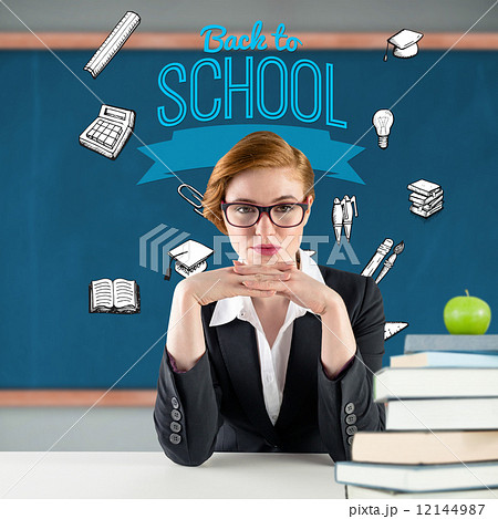 Composite image of redhead teacher sitting at desk Composite image of redhead teacher sitting at desk 12144987
