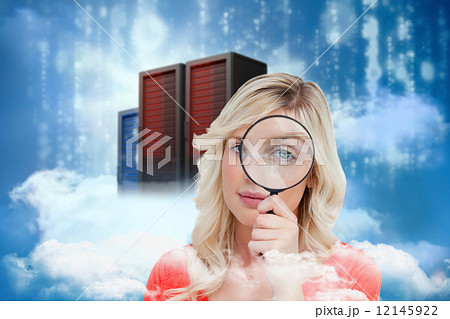 Composite image of fair-haired woman looking through a magnifyin 12145922