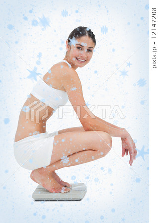 Composite image of slim young woman smiling while sitting on a s Composite image of slim young woman smiling while sitting on a s 12147208