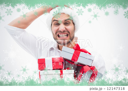Composite image of stressed festive man holding gifts 12147318