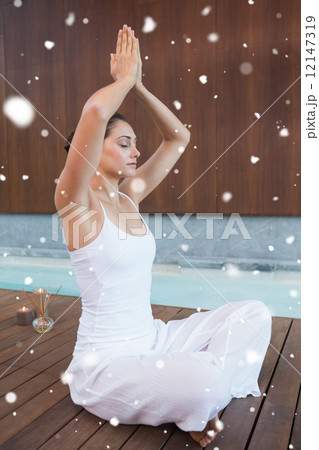 Composite image of content brunette in white sitting in lotus po 12147319