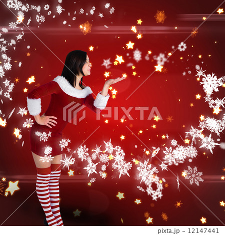 Composite image of pretty girl in santa outfit blowing 12147441