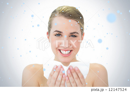 Composite image of smiling attractive blonde blowing her nose Composite image of smiling attractive blonde blowing her nose 12147524